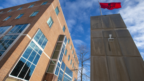 Flags wave in the breeze outside Alexander Library on College Avenue on a sunny morning