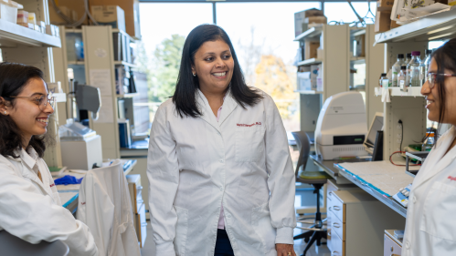 Harini Sampath speaking with two Aresty students in her research lab