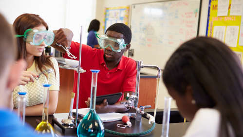 High school students carry out an experiment in a classroom