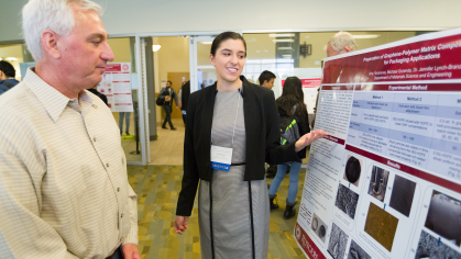 A student presenting her research poster