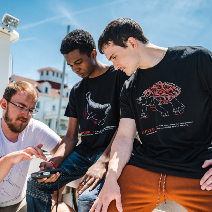 Rutgers Marine Field Station laboratory technician Douglas Hood (left) shows Jamin Brako (SOE '25; center) and Salvatore Fricano (SEBS '23) how to use equipment on the research boat.