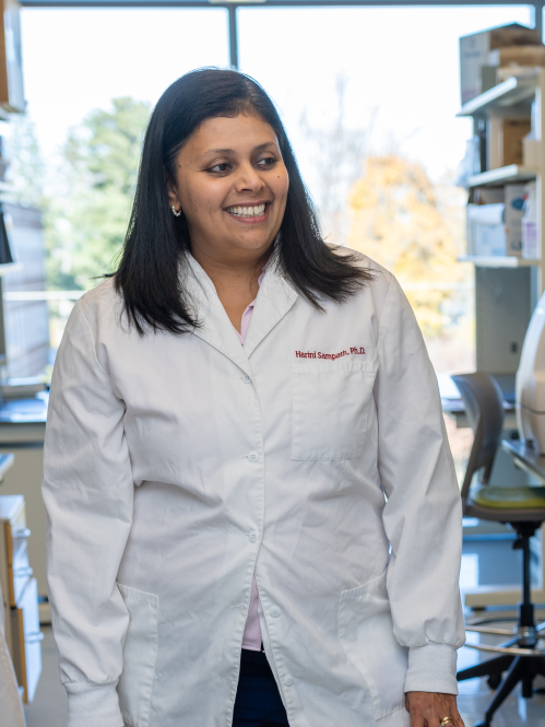 Harini Sampath speaking with two Aresty students in her research lab