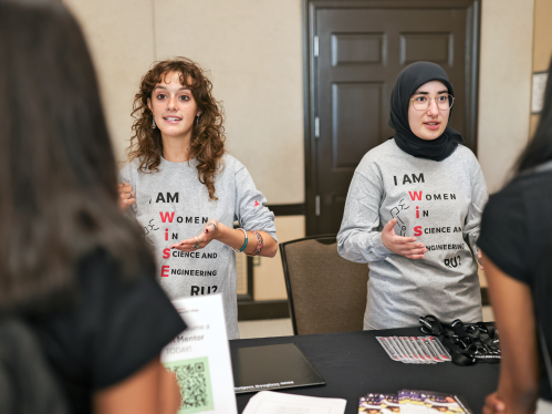 Two representatives from the Women in Science and Engineering speaking with students