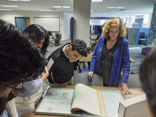 A group of students looking at Special Collections archives with a staff member in The Hatchery