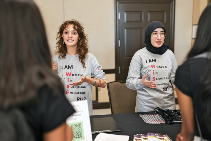 Two representatives from the Women in Science and Engineering speaking with students
