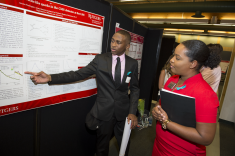 Antoine Washington presents his research poster Searching for Vector-like Quarks in the CMS Detector at the LHC to Tamiah Brevard, Aresty Director Undergraduate Research at the Aresty Research Center for Undergraduate Summer Science Poster Session.