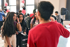 A group of students talking to a student presenter at the Undergraduate Research Discovery Day event